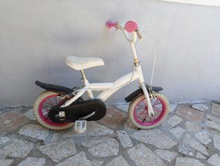 Bicicleta infantil blanca con ruedas rosas