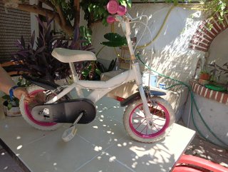 Bicicleta infantil blanca con ruedas rosas