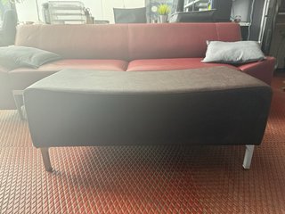 Otomana de cuero sintético marrón.