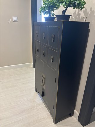 Mueble negro con detalles dorados.