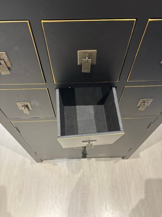 Mueble negro con detalles dorados.