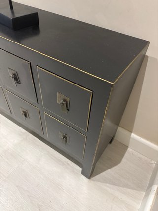 Mueble pequeño negro con detalles dorados