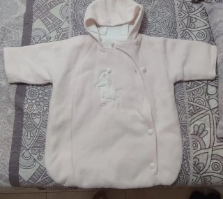 Saco para bebé rosa con capucha.