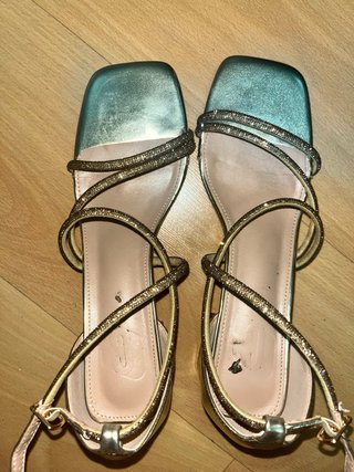 Tacones dorados brillantes con tiras