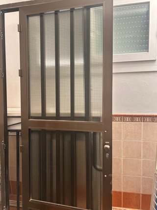 Puerta exterior metálica con reja