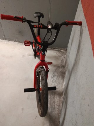 Bicicleta Trial Roja con soportes en las ruedas.