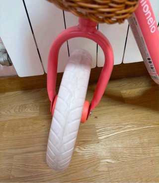 Bicicleta de equilibrio rosa con cesta.