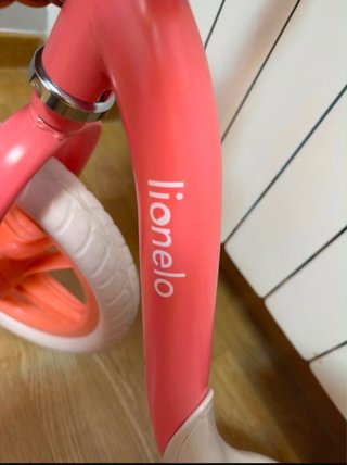 Bicicleta de equilibrio rosa con cesta.