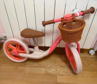 Bicicleta de equilibrio rosa con cesta.