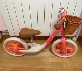 Bicicleta de equilibrio rosa con cesta.