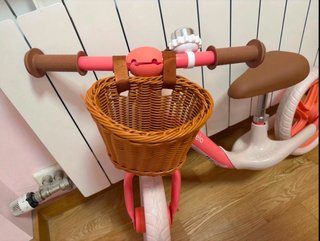 Bicicleta de equilibrio rosa con cesta.