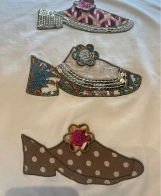 Camiseta blanca con apliques de zapatos
