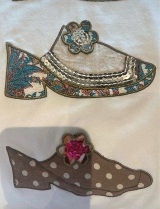 Camiseta blanca con apliques de zapatos