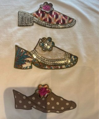 Camiseta blanca con apliques de zapatos