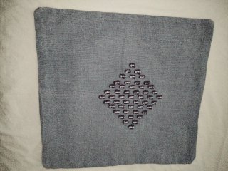 Funda de cojín gris con diseño de rombo
