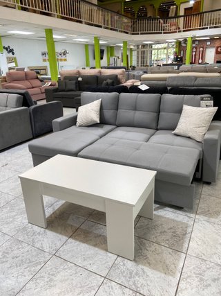 Sofa cama gris moderno con mesa blanca