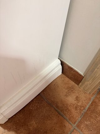 Cómoda y mesita blancas con tiradores de cristal.