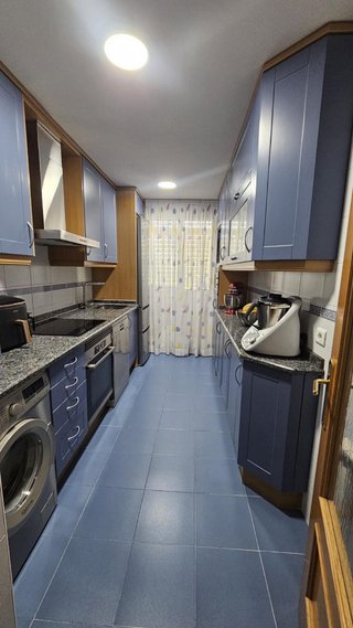 Cocina azul y marrón con encimera de mármol