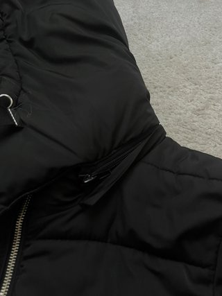 Abrigo plumífero negro con capucha