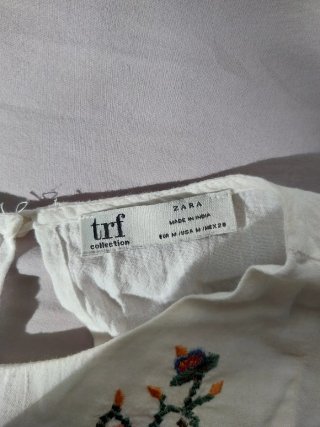 Blusa blanca bordada con pompones estilo boho.