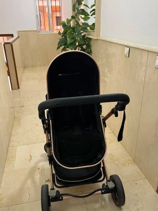 Carrito de bebé negro y dorado