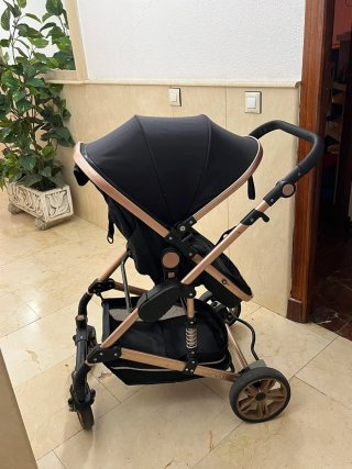 Carrito de bebé negro y dorado