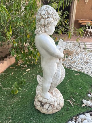 Escultura de niño con pato