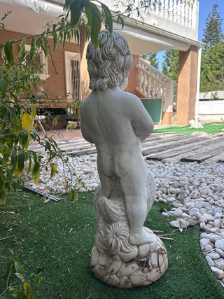 Escultura de niño con pato