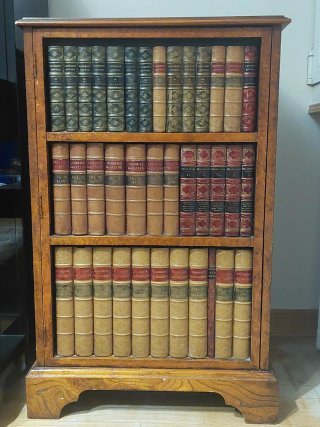 Mueble de madera con decoración de libros antiguos