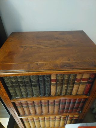 Mueble de madera con decoración de libros antiguos