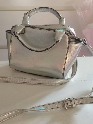 Bolso plateado de mano y bandolera