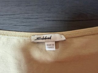 Top beige manga larga con nudo