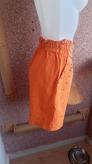 Pantalón corto naranja con tachuelas plateadas