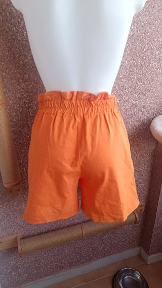 Pantalón corto naranja con tachuelas plateadas
