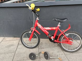 Bicicleta infantil roja con ruedines