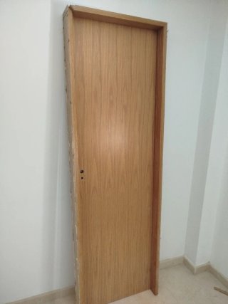 Puerta maciza y marco de madera clara
