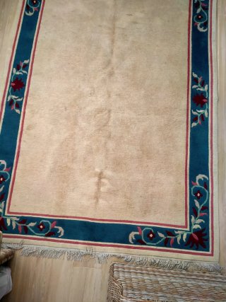 Alfombra beige con borde azul y flores