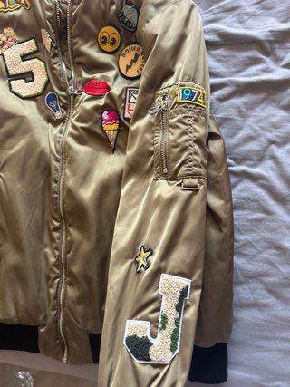 Chaqueta bomber dorada con parches