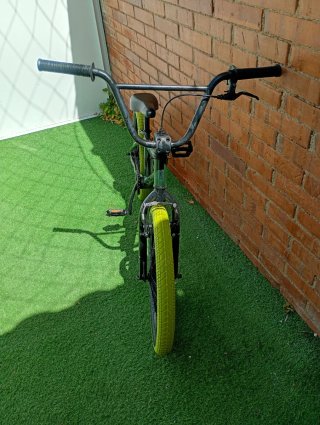 Bicicleta BMX verde con ruedas amarillas
