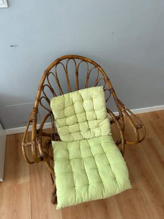 Sillón de ratán con cojines verdes