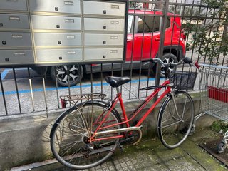 Bicicletta da città rossa con cestino
