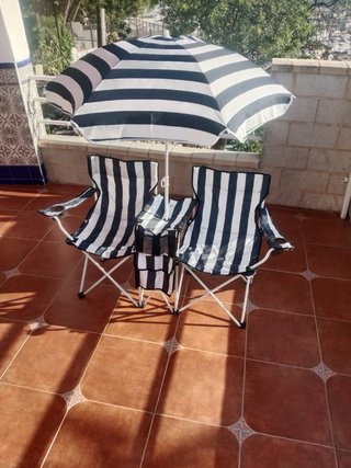 Sillas de playa a rayas y sombrilla