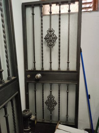Puerta de hierro forjado con cristal.