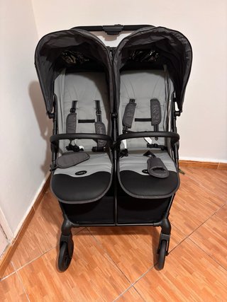 Carro gemelar gris con bolso y cambiador