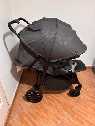 Carro gemelar gris con bolso y cambiador