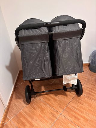 Carro gemelar gris con bolso y cambiador