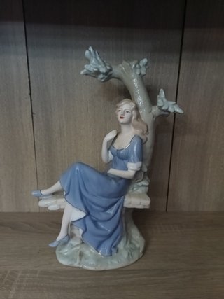 Figura mujer sentada en árbol