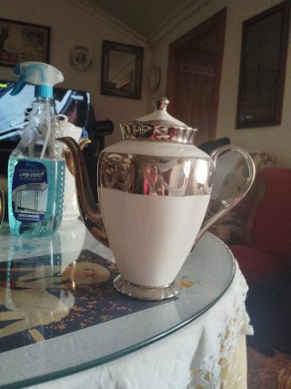 Cafetera blanca con detalles plateados