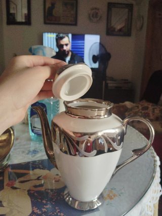 Cafetera blanca con detalles plateados