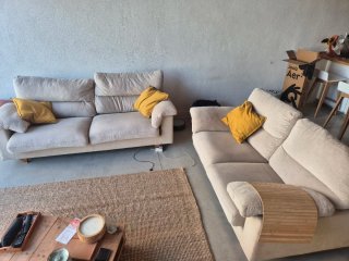 Conjunto sofás de tela beige con cojines amarillos